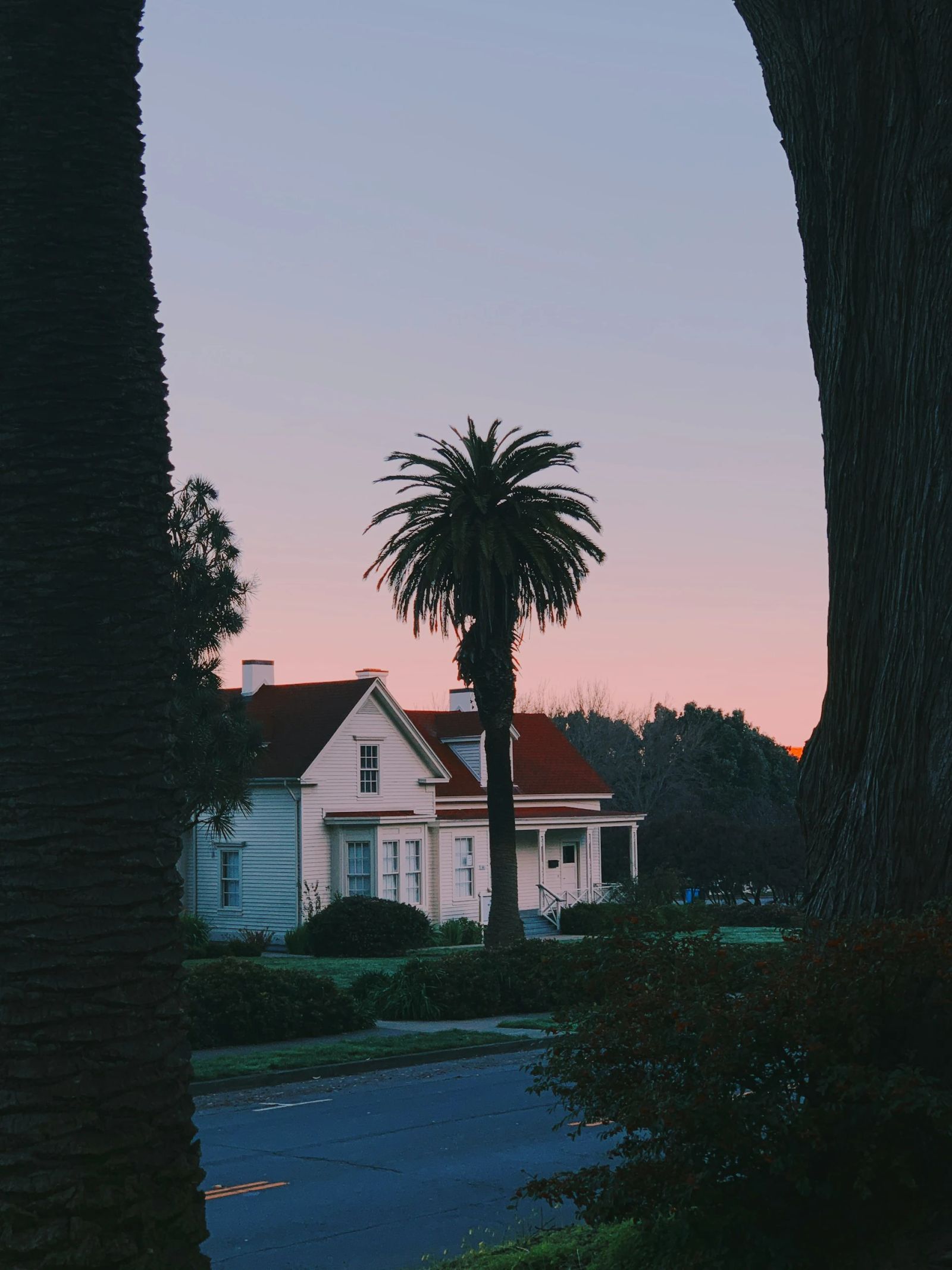 Cosy house entrance at dusk with lights and flowers.